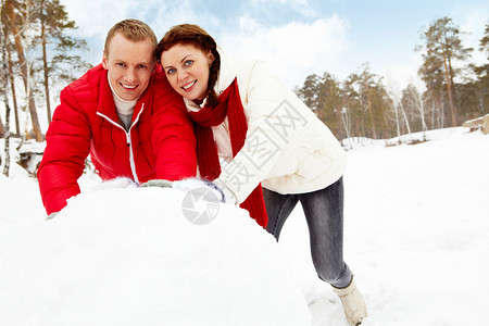 幸福的夫妇在寒假堆雪人的肖像图片