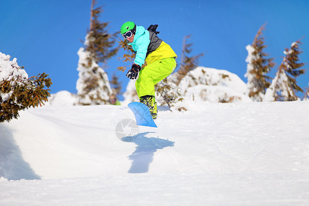 跳跃在山坡的单板滑雪者图片