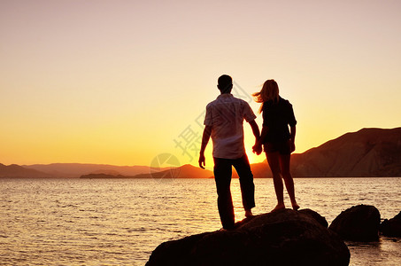 一对夫妇在海边看着太阳图片
