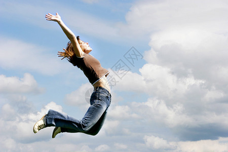 天空背景上跳跃的女孩图片