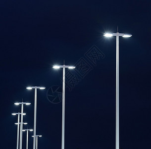 现代街道灯在夜晚对着黑图片