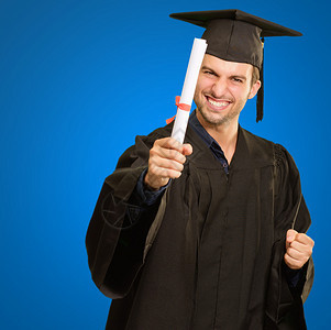 毕业男子在蓝色背景上孤立持图片