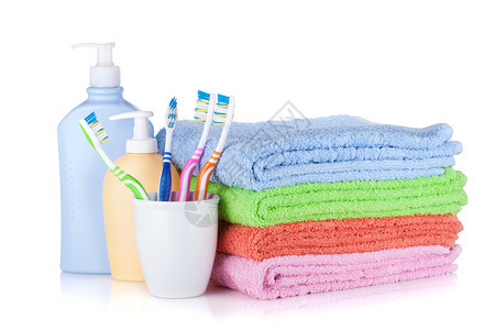 牙刷洗发水瓶和彩色毛巾在白色背景下被隔离图片