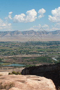 科罗拉多纪念碑边缘的砂岩中的口袋会收集雨水大峡谷和书崖就在不远处悬崖下方弯曲的河流图片