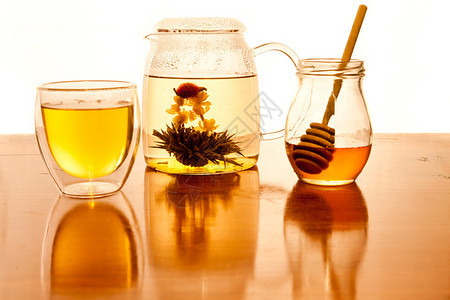 一只手在玻璃茶壶里做了绿色茶叶花棚图片
