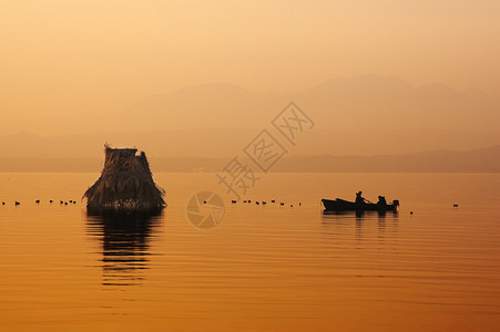日落时渔船的黑色剪影加尔达湖图片