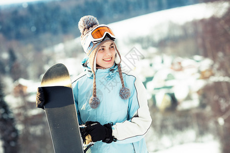 年轻女子拿着雪板图片