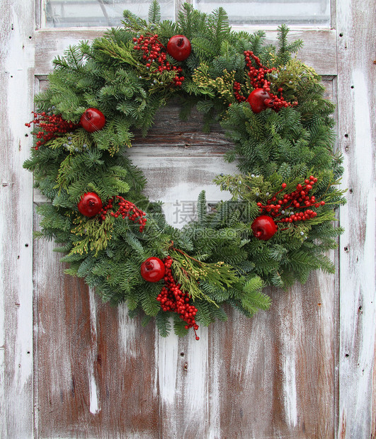 质朴的木制前门上的圣诞花环图片