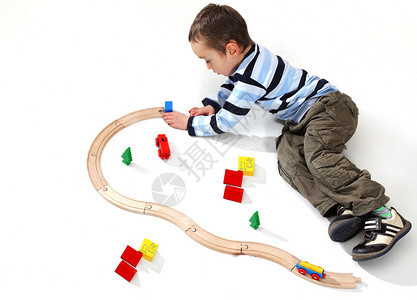 4岁的幼儿男孩玩木制火车打演播室背图片
