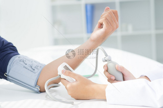 检查她的病人的血压的护士图片