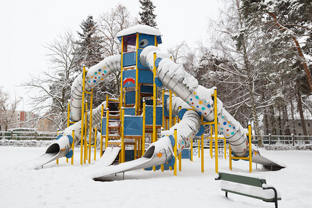 暴风雪后儿童游乐场公园的雪滑梯图片