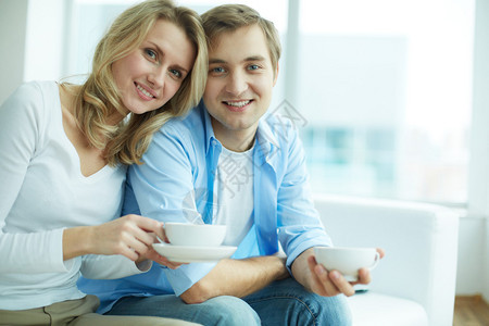 年轻人和女友在喝茶时看镜头图片