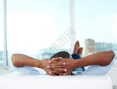 年轻非洲男子躺在沙发图片