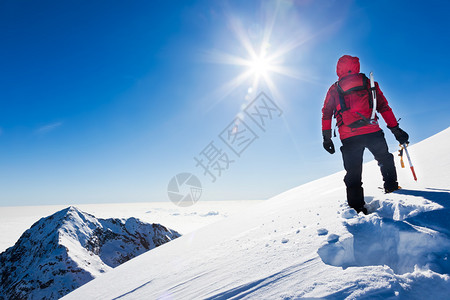 登山者在阳光明媚的冬天到达雪山顶意大利西阿尔图片