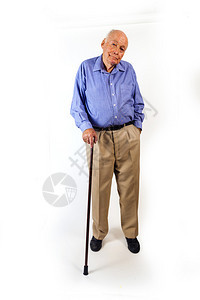 快乐的老年男子站在他的徒步棍旁在图片