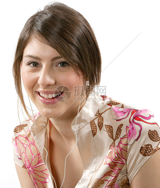 近距离的肖像一个迷人的快乐女人用她的耳机听音乐在白色背景下被孤立了图片
