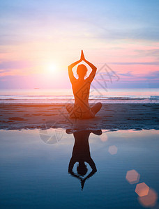 一个女人在日落时做瑜伽的休图片