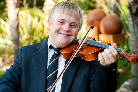 在户外玩小提琴的友好残疾儿图片