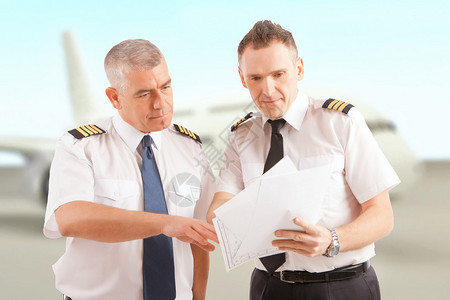 身穿制服佩有单板检查证件背景客机和客机图片