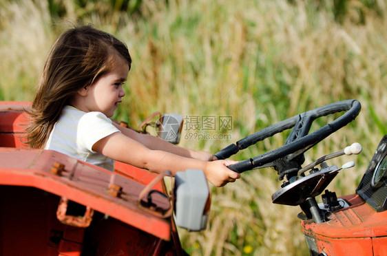 小女孩开着一辆旧拖拉机图片