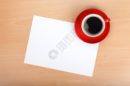 木桌上的白纸和红色咖啡杯图片