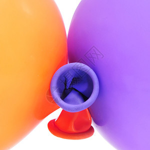 白色背景上橙色和紫色气球的特写图片