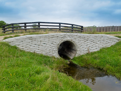 大型圆形雨水涵洞或排水管穿过风景秀丽的乡村道路图片