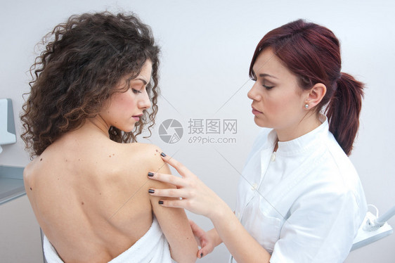 皮肤病医生检查妇女皮肤的图片