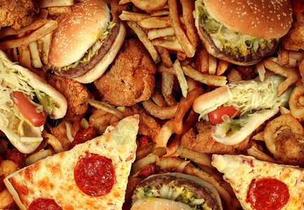 油炸餐厅的快餐概念作为洋葱圈汉堡和热狗搭配炸鸡薯条和比萨饼作为饮食诱惑的象征背景图片