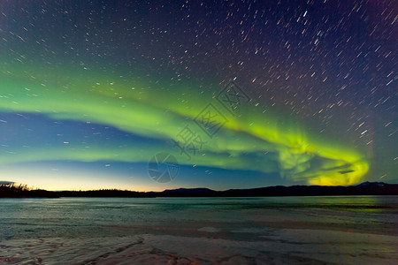 强烈的北极光或北极光或极光和晨曦在夜空中的冰冷的拉贝热湖育空地区加拿大图片