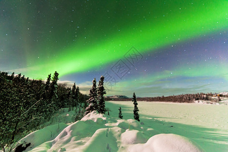 壮观的北极光或北极光或极光在加拿大育空地区结冰的拉贝热湖冬季景观上图片