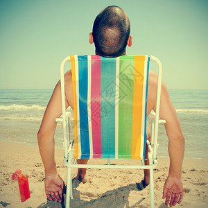 在沙滩的甲板椅上用鸡尾酒晒太阳并图片