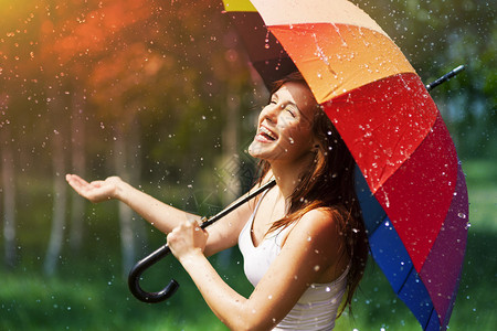 带伞检查雨的笑女人图片