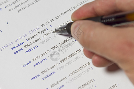 一个程序员人用他的笔指着Java计算机代码软件应用程序代码X图片