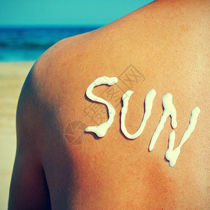 在海滩上晒日光浴的人背面写着太阳与防晒霜同字并图片