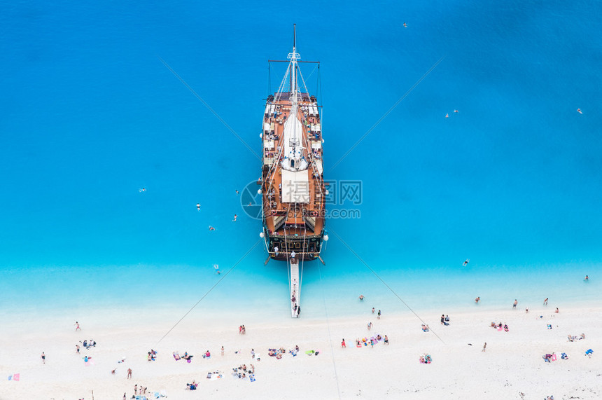 大型帆游轮停靠在白沙滩上图片