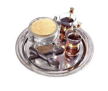 托盘巧克力汤匙和棕糖上的土耳其茶杯图片