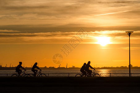 海上日落骑自行车的人剪影图片