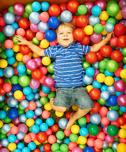 快乐的孩子在多彩的塑料球操场图片