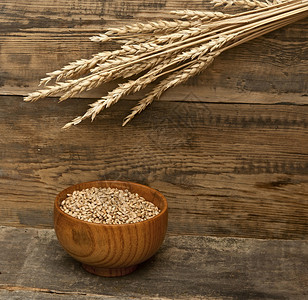 木材纹理背景上的小麦穗图片