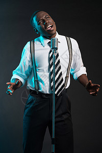 带麦克风的非洲爵士歌手穿着衬衫和领带图片