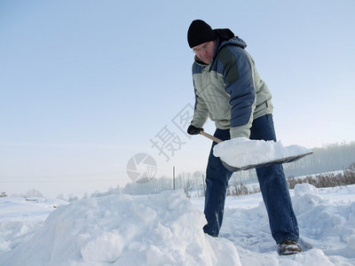 大型暴风雪过后用雪铲扫雪人从图片