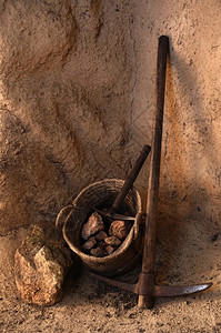 古老的采矿工具和一篮子装满了矿坑图片