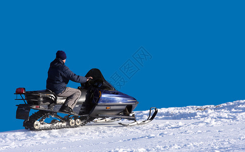 男子在冬山驾驶雪地摩托图片