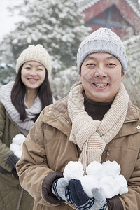 在公园里拿着雪球的情侣图片