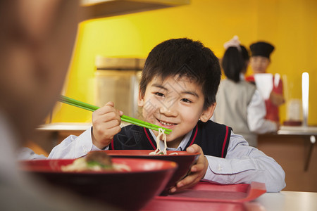小学生在学校食堂吃面条图片