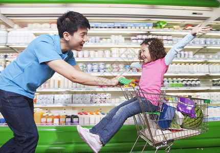父亲在超市里把女儿推进购物图片