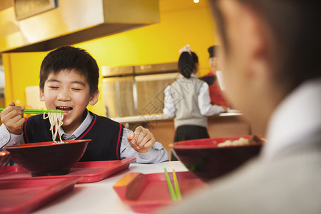 小学生在学校食堂吃面条图片