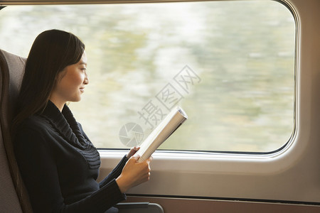 年轻女在骑火车时看杂图片