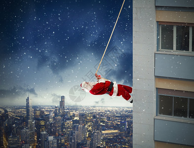 圣诞老人在夜间爬上建筑物图片